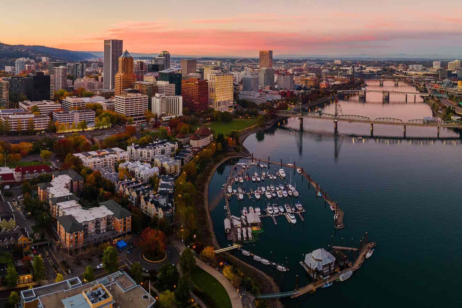 Downtown Portland Oregon, including a river to the right of the frame and a skyline to the left, all shown at dusk.